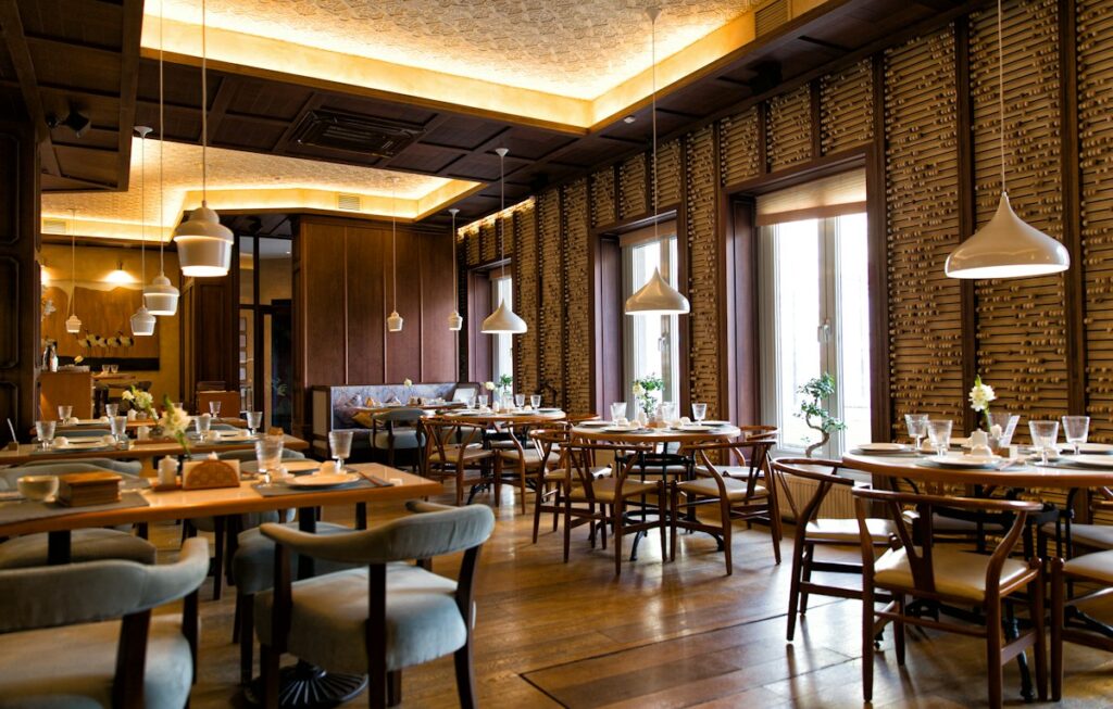 Restaurant interior with wood wall paneling, warm lighting and wooden tables — reference photo